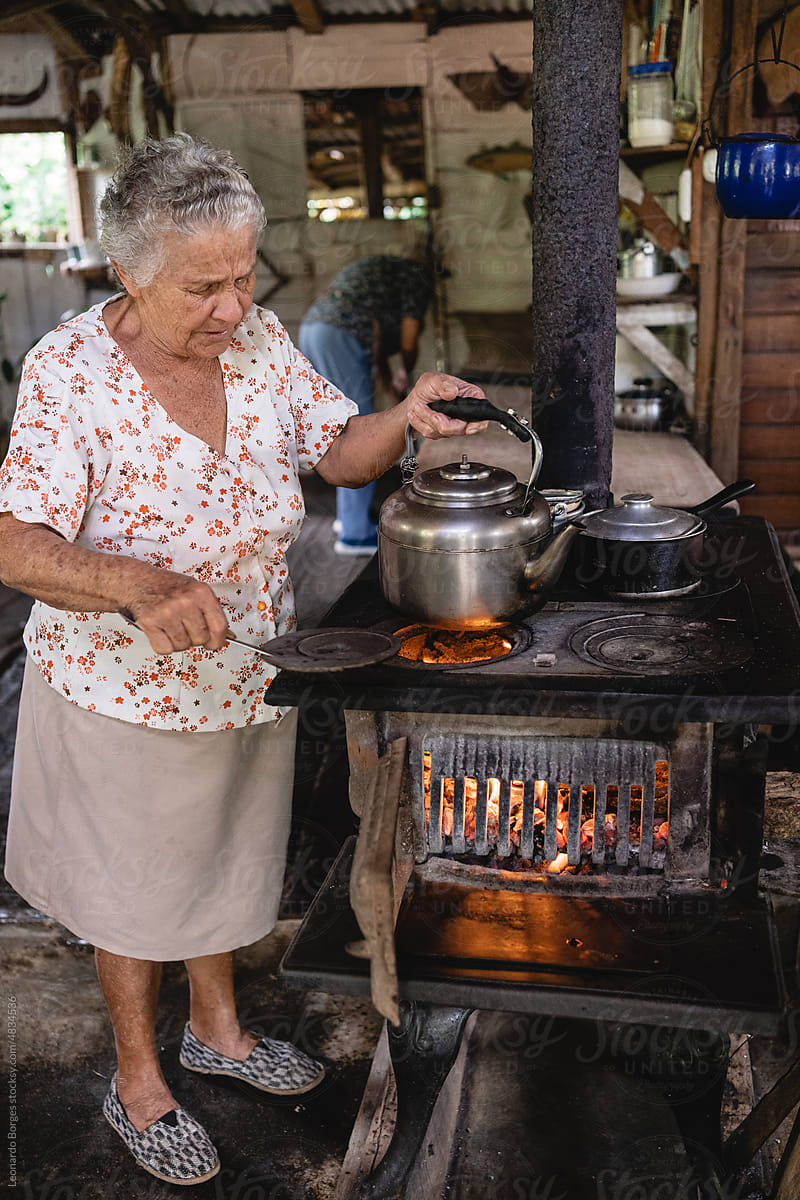 Elderly woman cooking.