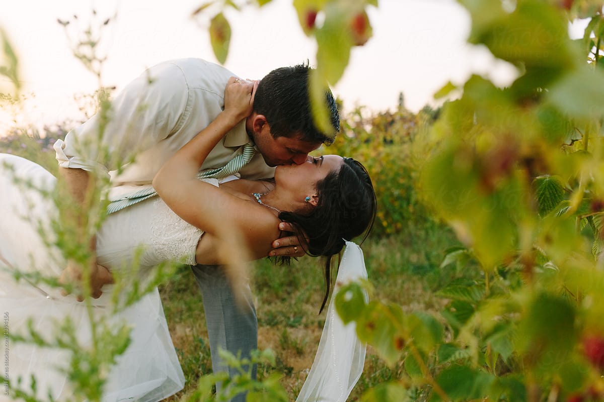 Wedding Couple Dips and Kisses in Farm Field