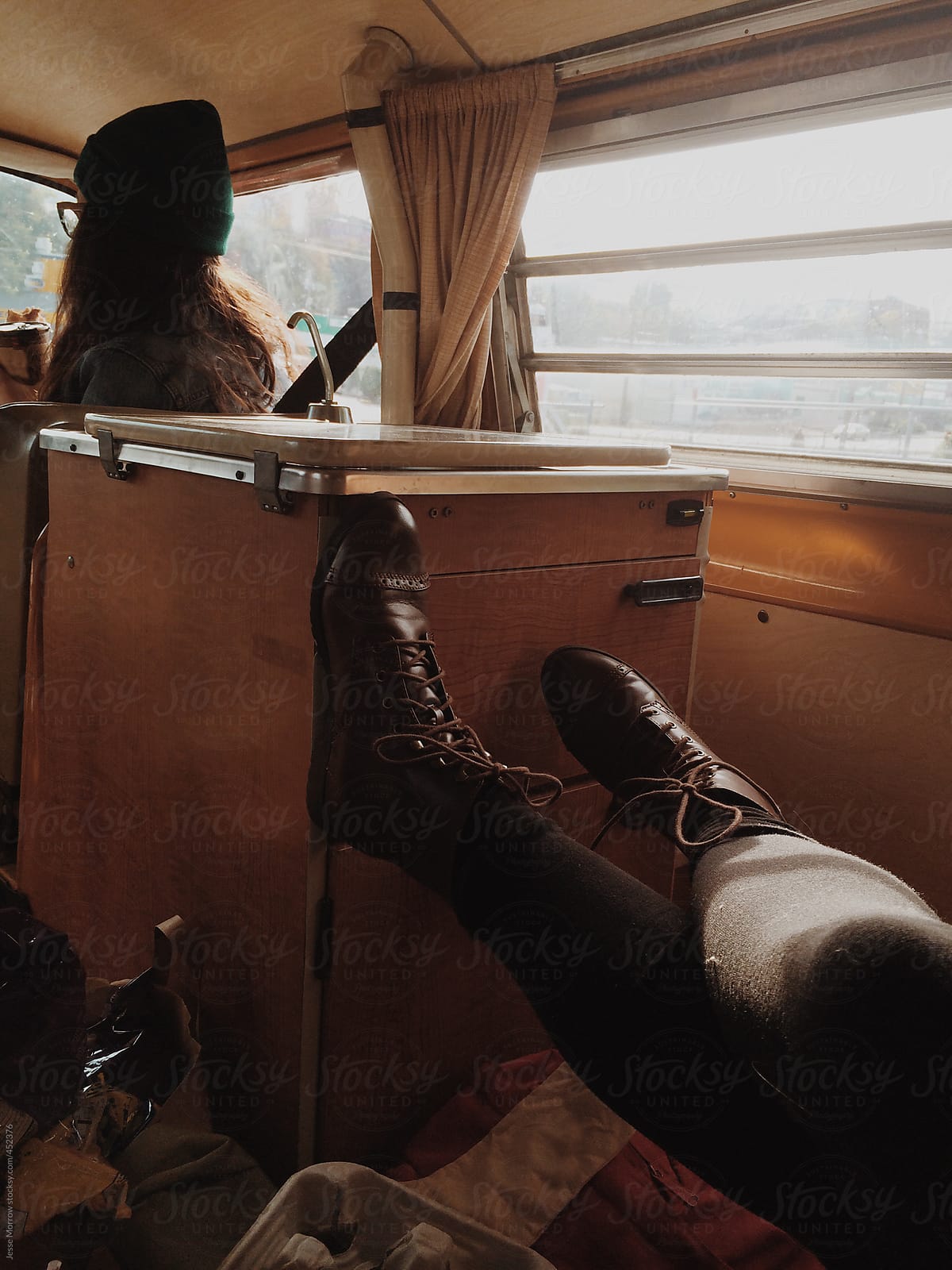 young woman props feet up in relaxing van ride