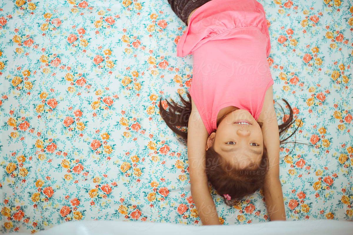 Girl on floral bedsheet