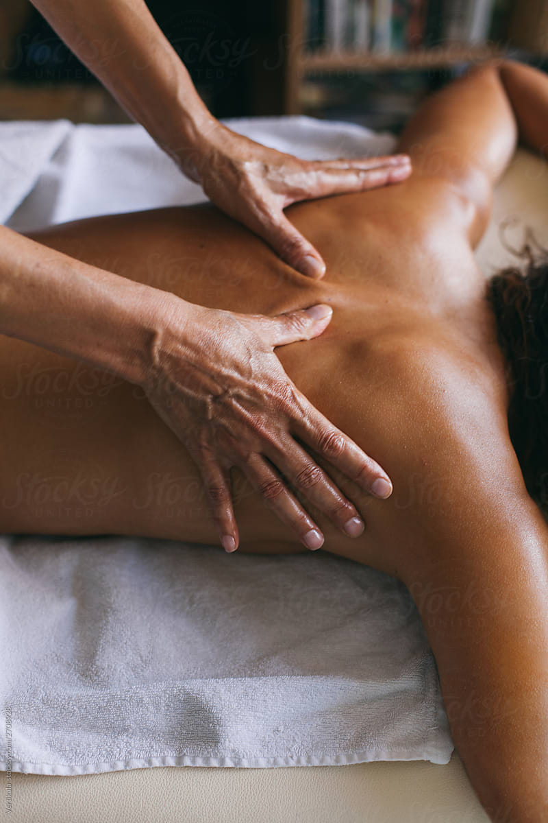 Masseur doing massage of female back indoor