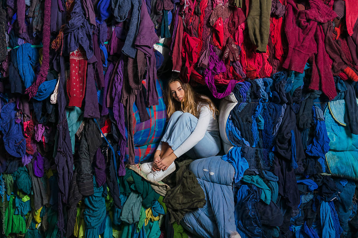 Young Woman with Used Clothes for Recycling