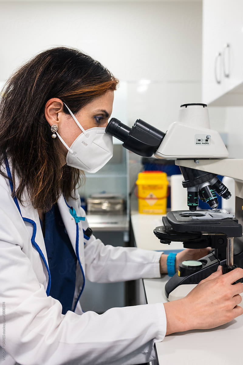 Embryologist with microscope conducting fertilization in lab
