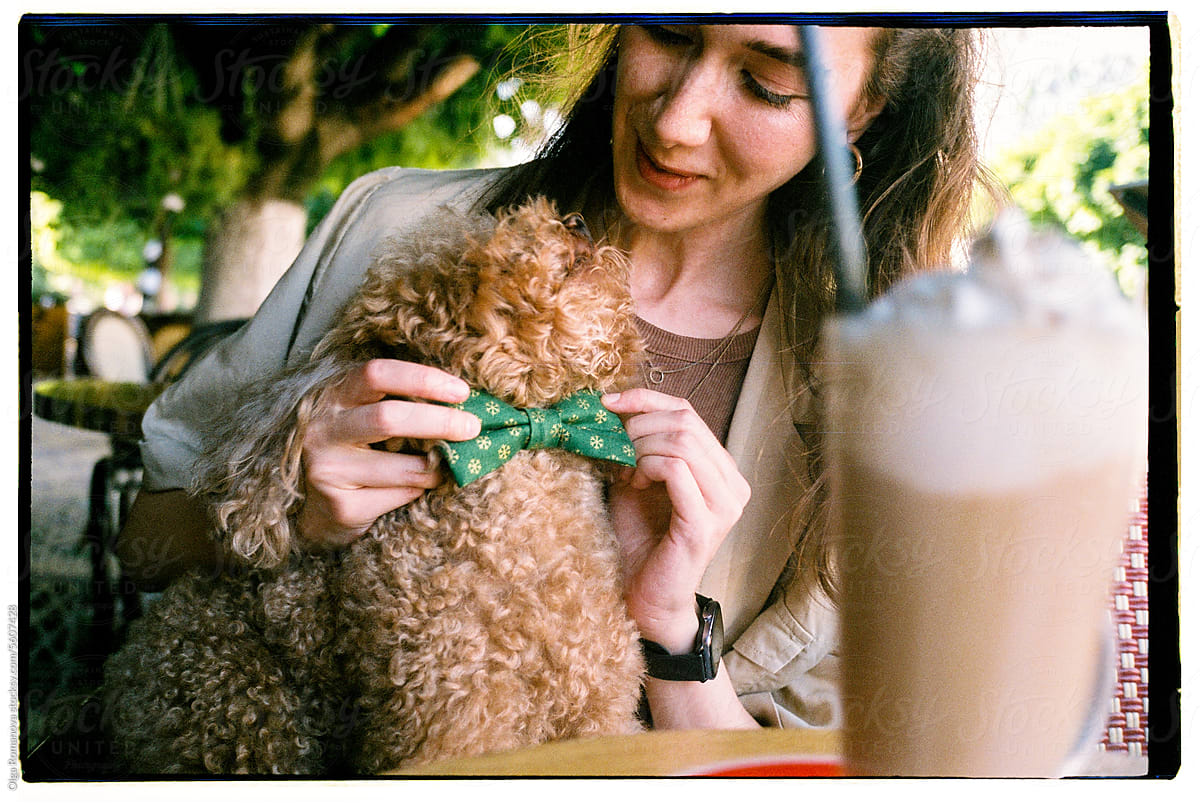 Closeup portrait of young woman with dog in a cafe