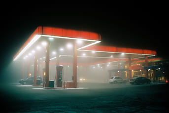 Vintage gas station in the rain and fog at night. it schould give a  melancholical feeling on Craiyon