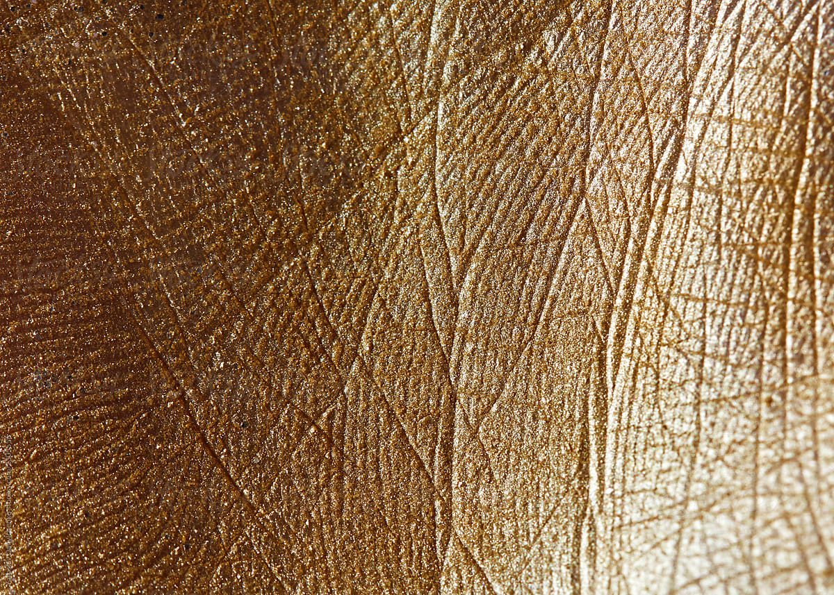 Handbreadth with a pattern of lines painted with golden powder. Macro photo