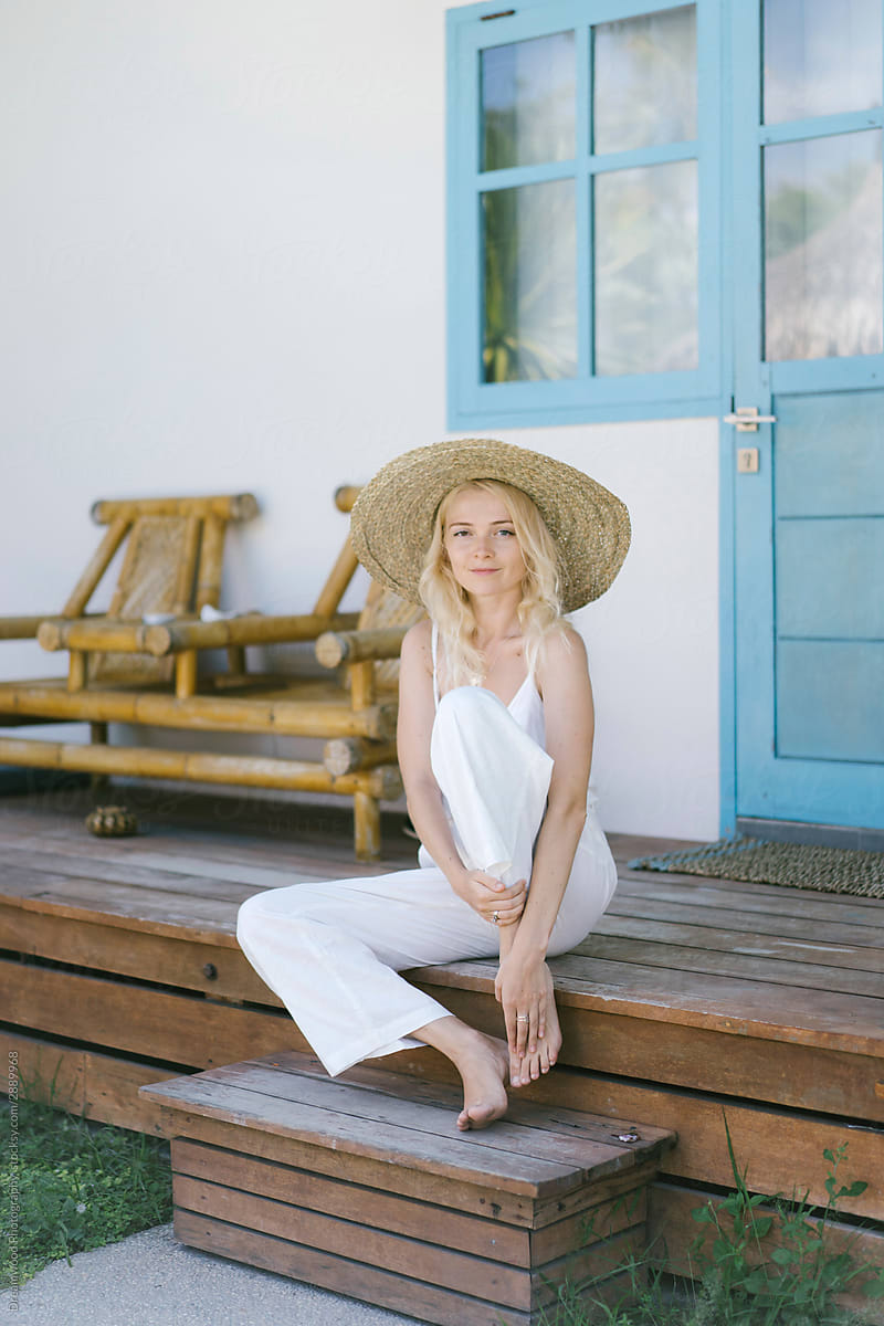 Carefree woman on vacation in straw hat at rural patio