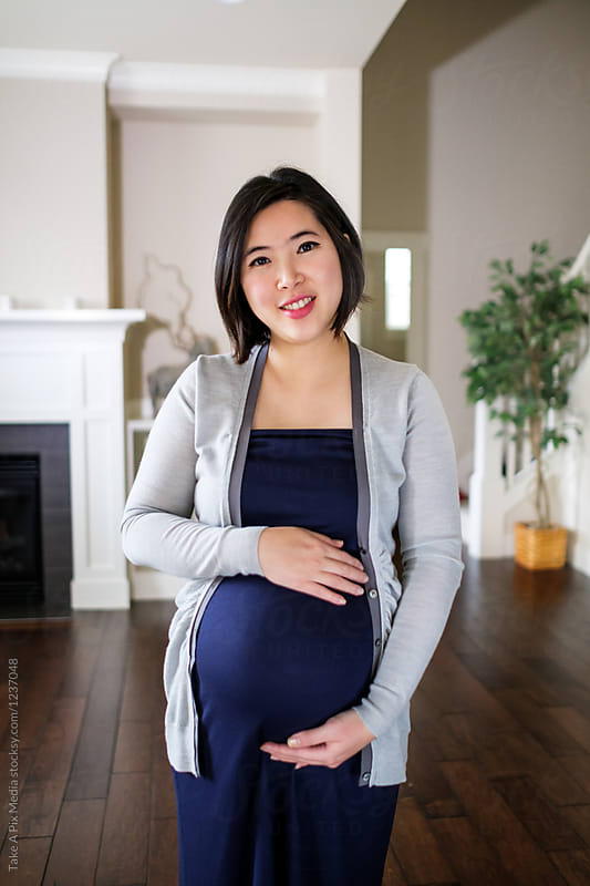 Pregnant Asian woman at home by Suprijono Suharjoto ...