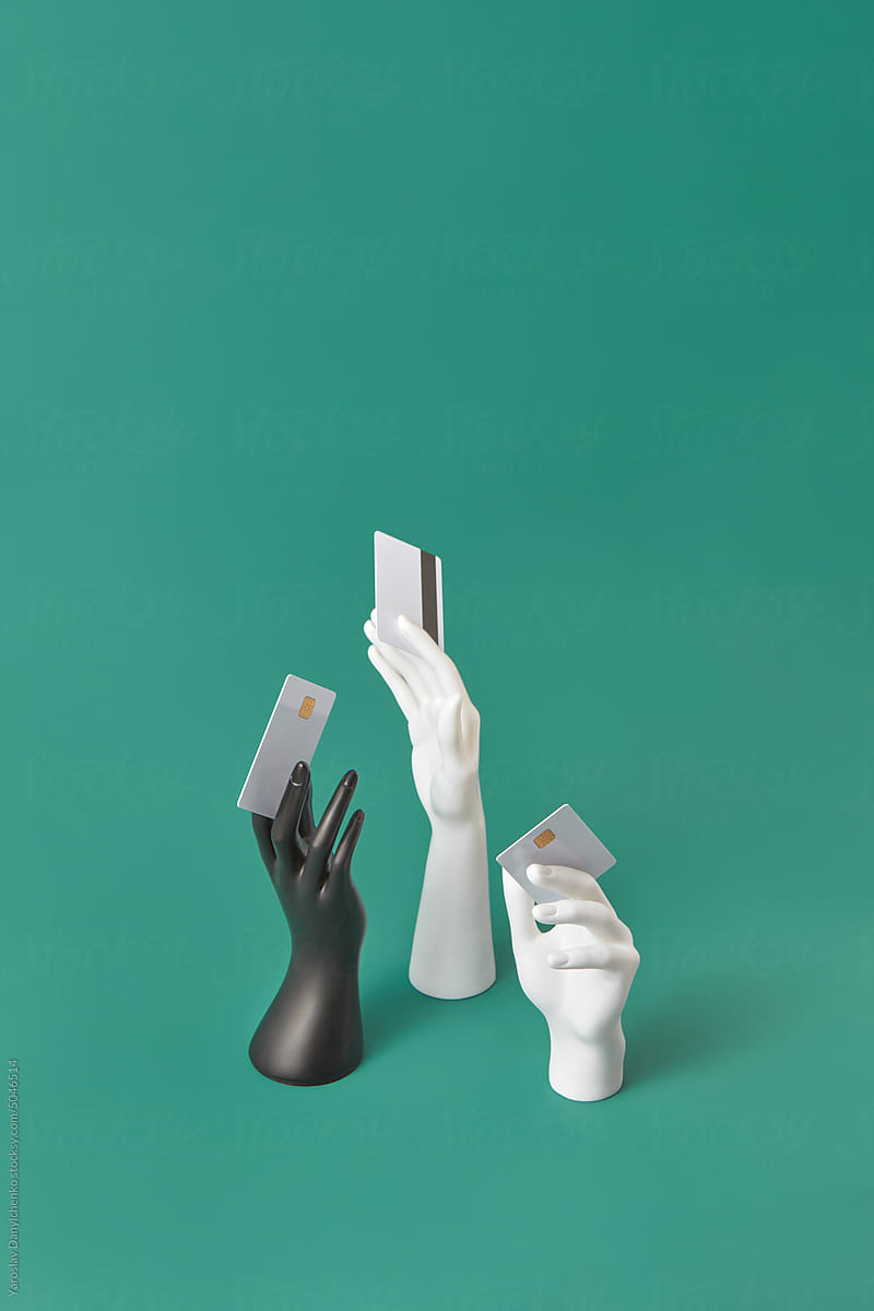 Black and white human hands holding credit cards.