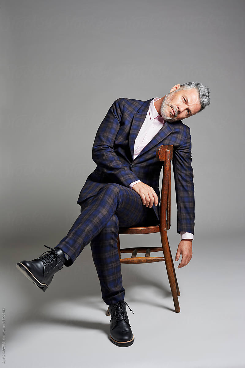Portrait of an elegant man sitting on the chair by ALTO IMAGES
