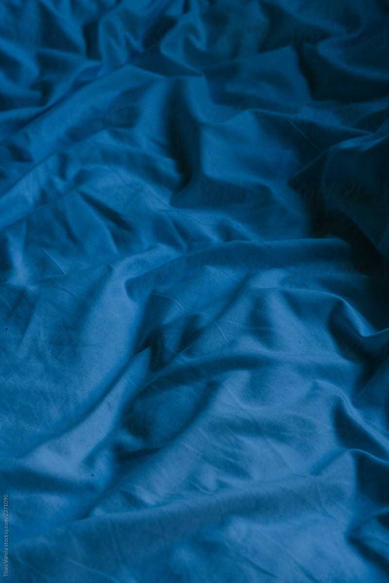 crumpled blue sheets reminiscent of the sea