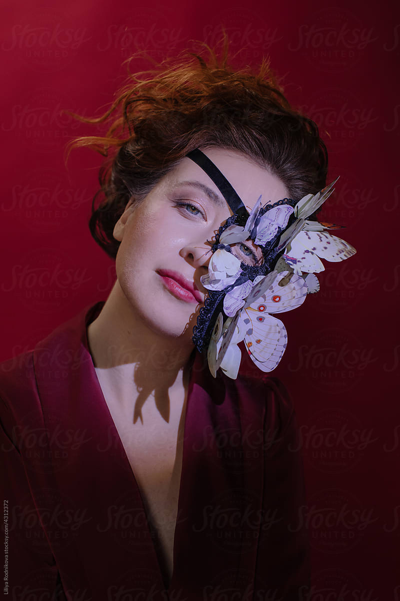 Female model in butterfly mask looking at camera