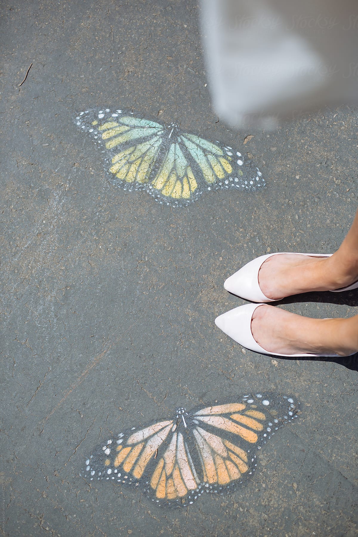 Feet with butterflies drawn on the ground
