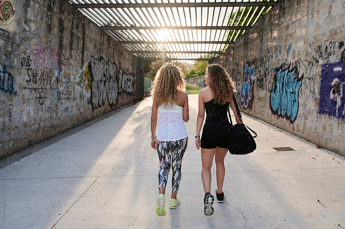 Fit mom and daughter walking outside