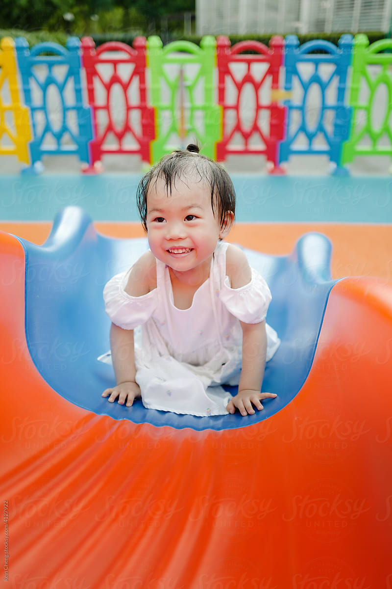 Asian baby playing on a slide