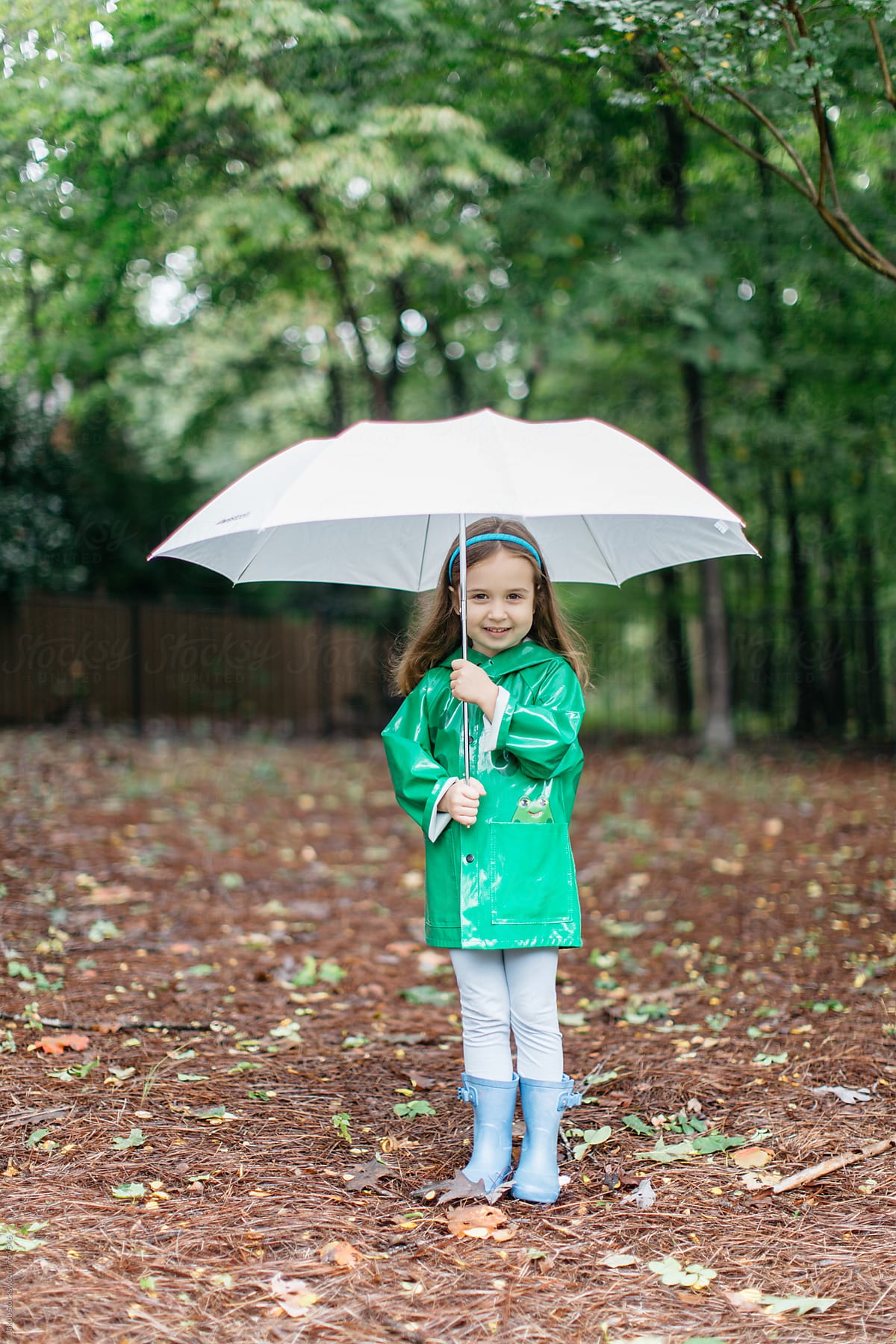 Cute young toddler with an umbrella and raincoat