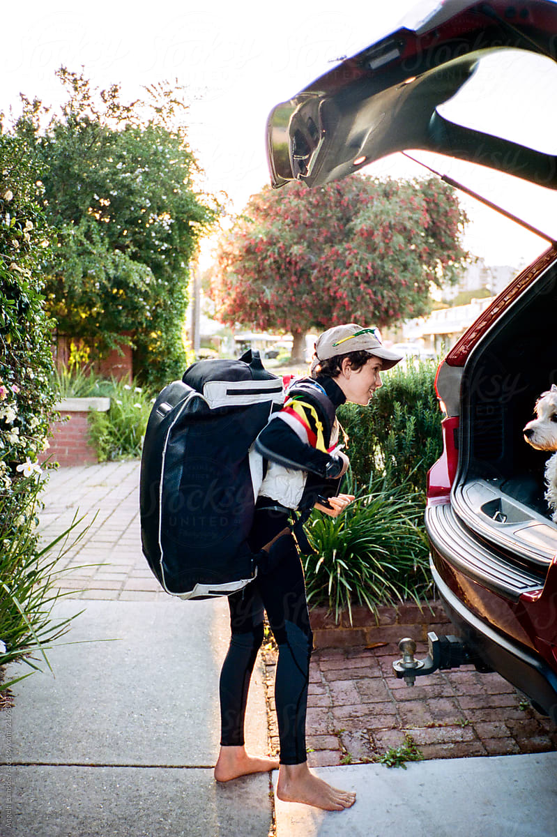 Teenage boy unloading his sailing gear from a car