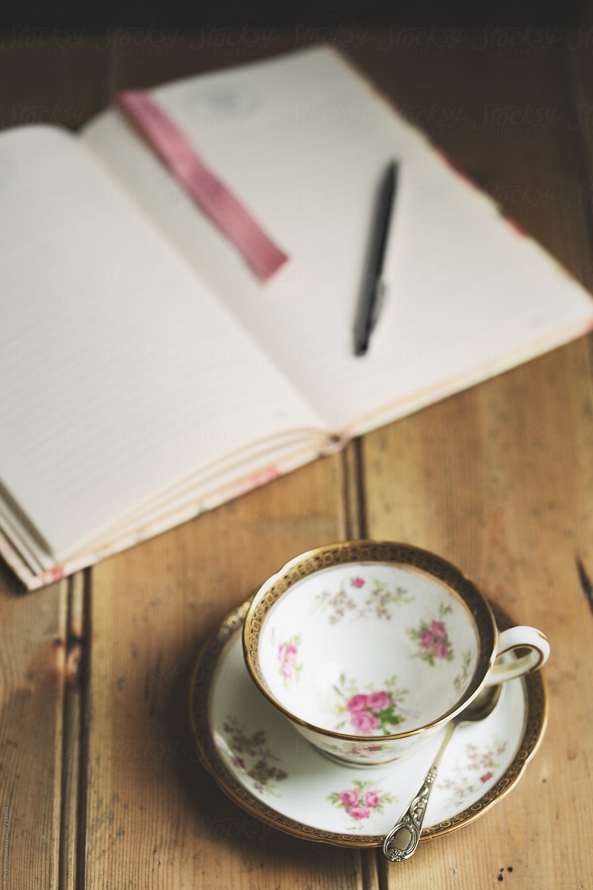 Open journal with vintage floral teacup