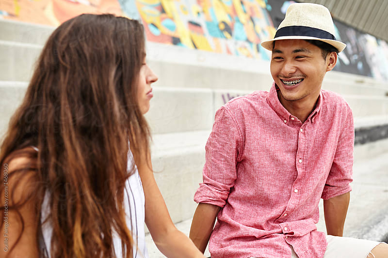 Happy man in stylish hat smiling at girlfriend.