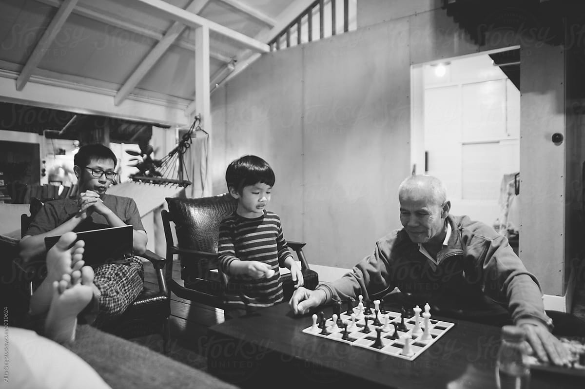 Asian family playing board game at home