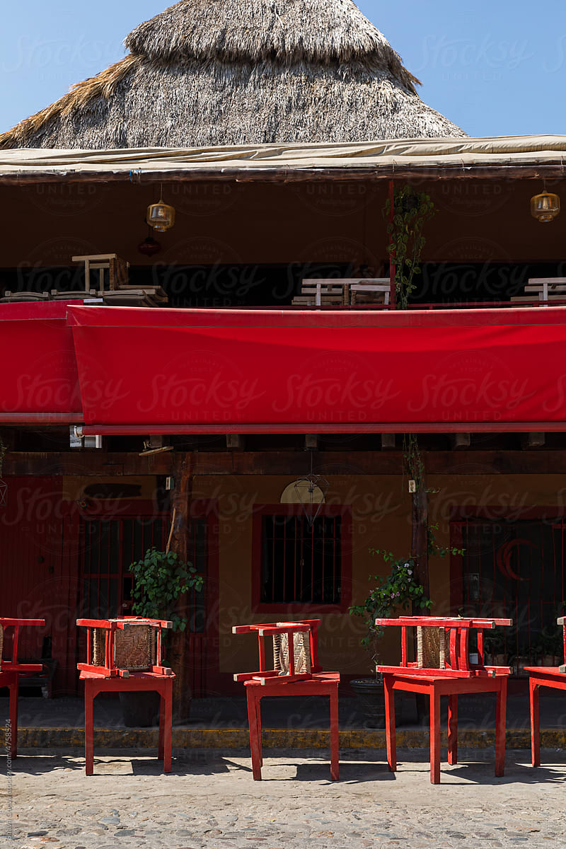 Red chairs and tables in front of a closed restaurant