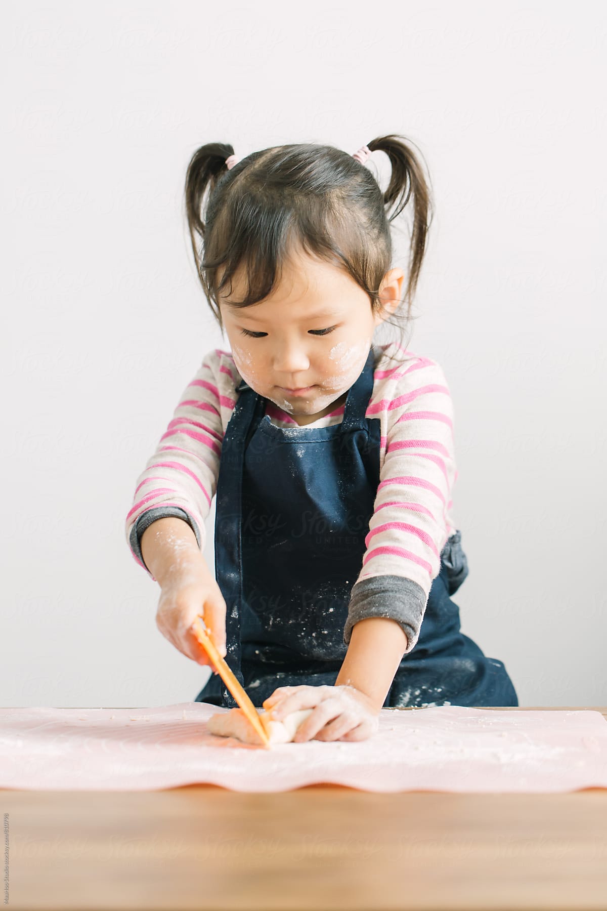 Toddler girl cutting dough