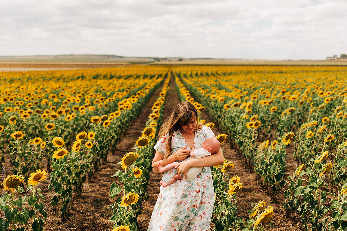 Mother and daughter in field of sunflowers