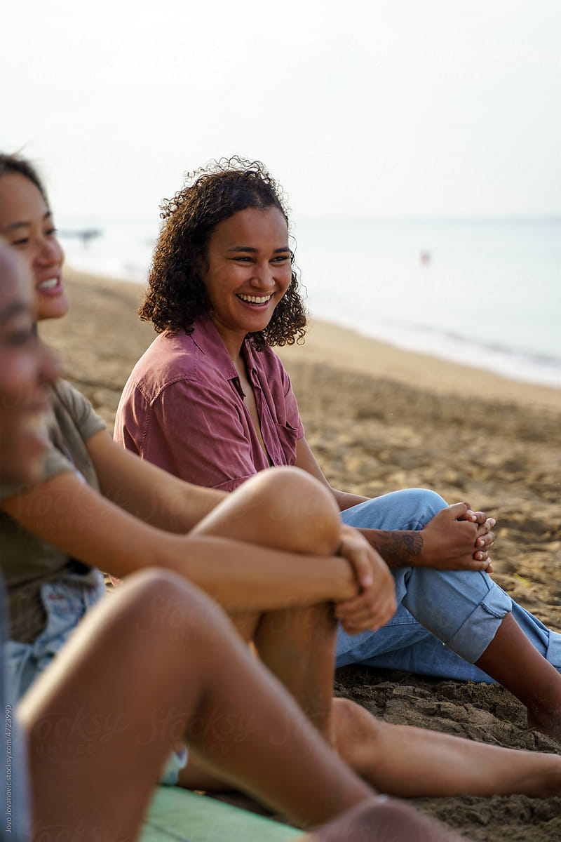 Woman with curly hair smiling while hanging out with friends