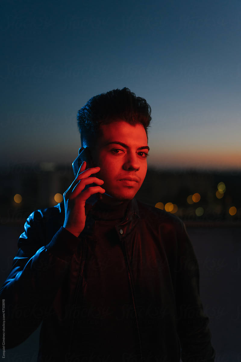 Young man speaking on smartphone in evening