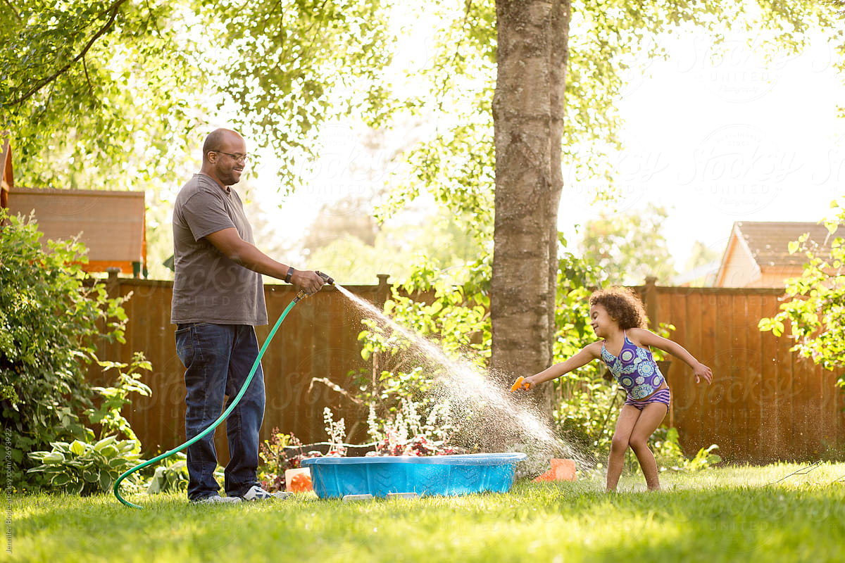 Father sprays daughter\'s feet with hose