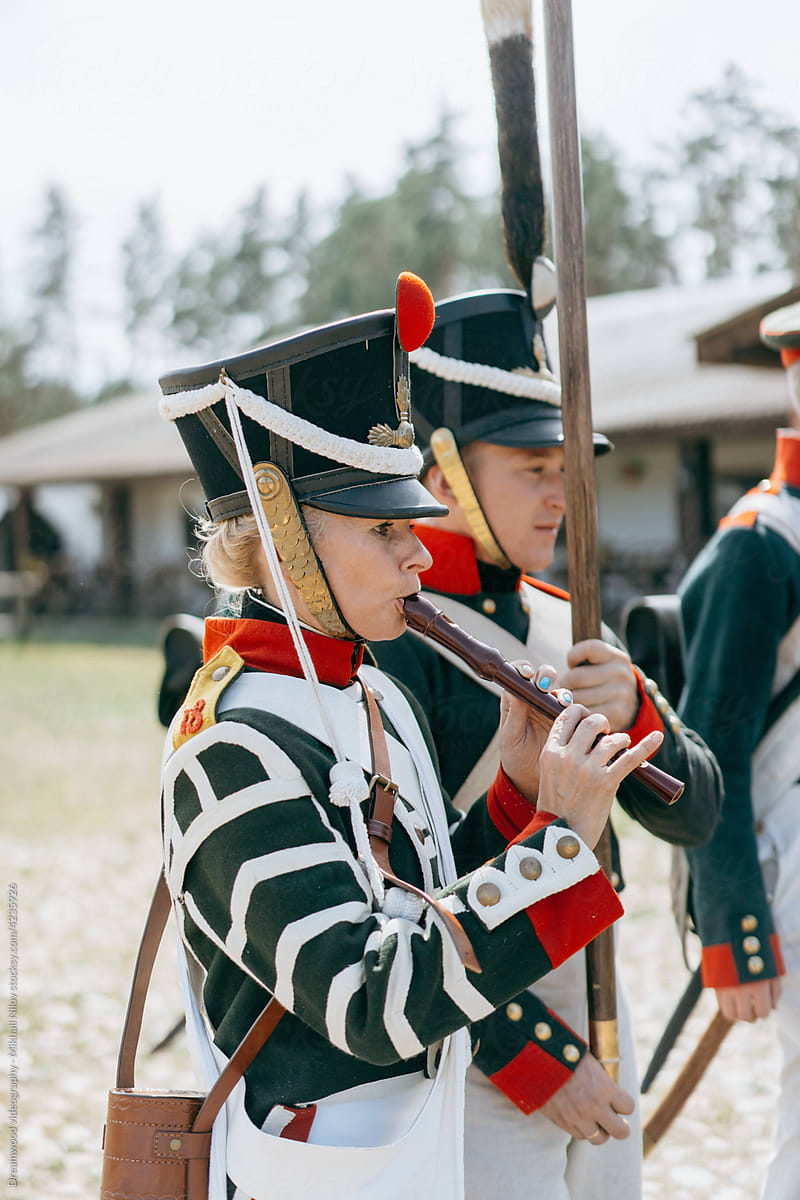 A woman soldier in a beautiful uniform plays the flute
