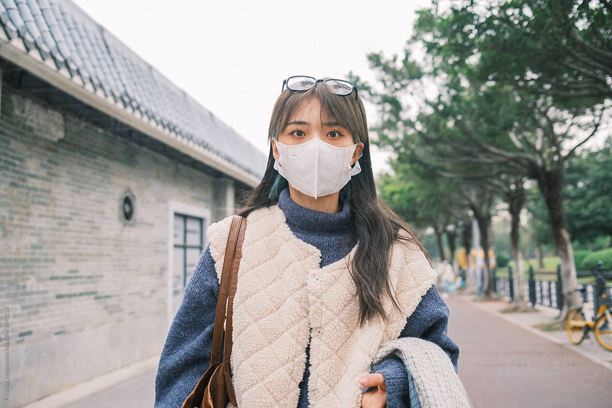 Young woman with mask walking in the street