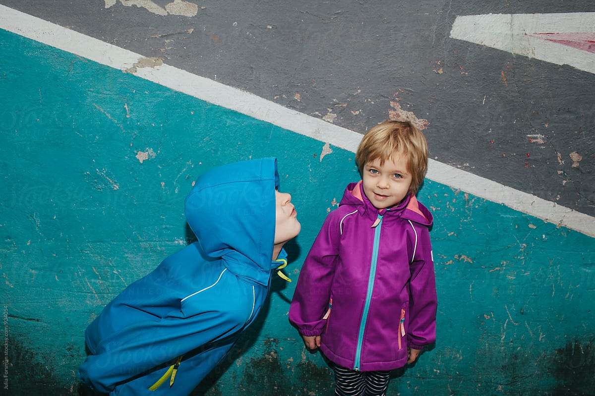 Bright, urban image of a little girl amused by her brother\'s antics.