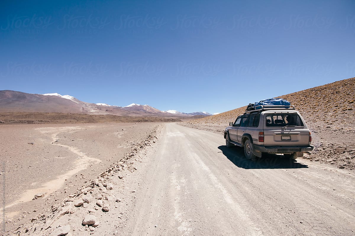 4wd car on desert dirt road with mountains