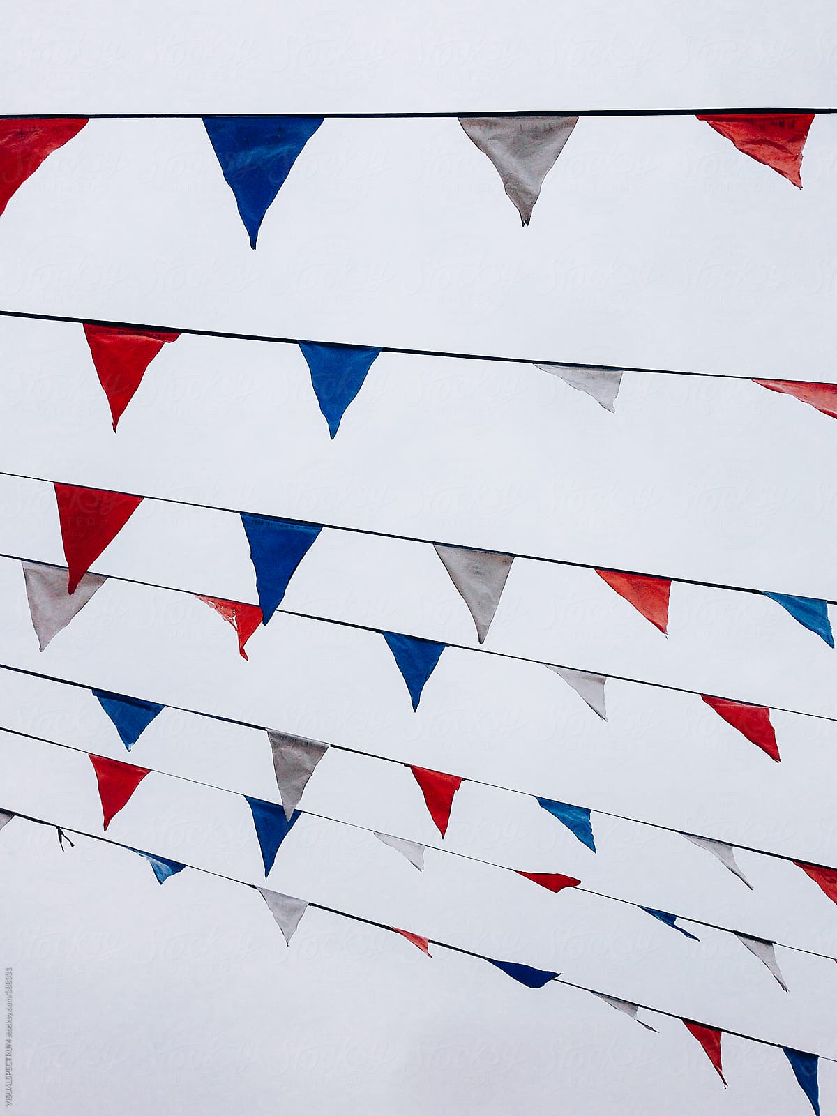 Many Small Triangular Flags in American Colors Hanging on Line