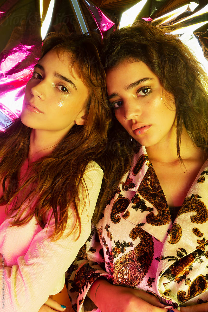 Close-Up Of Young Women With Colorful Illuminated Lights In Darkroom