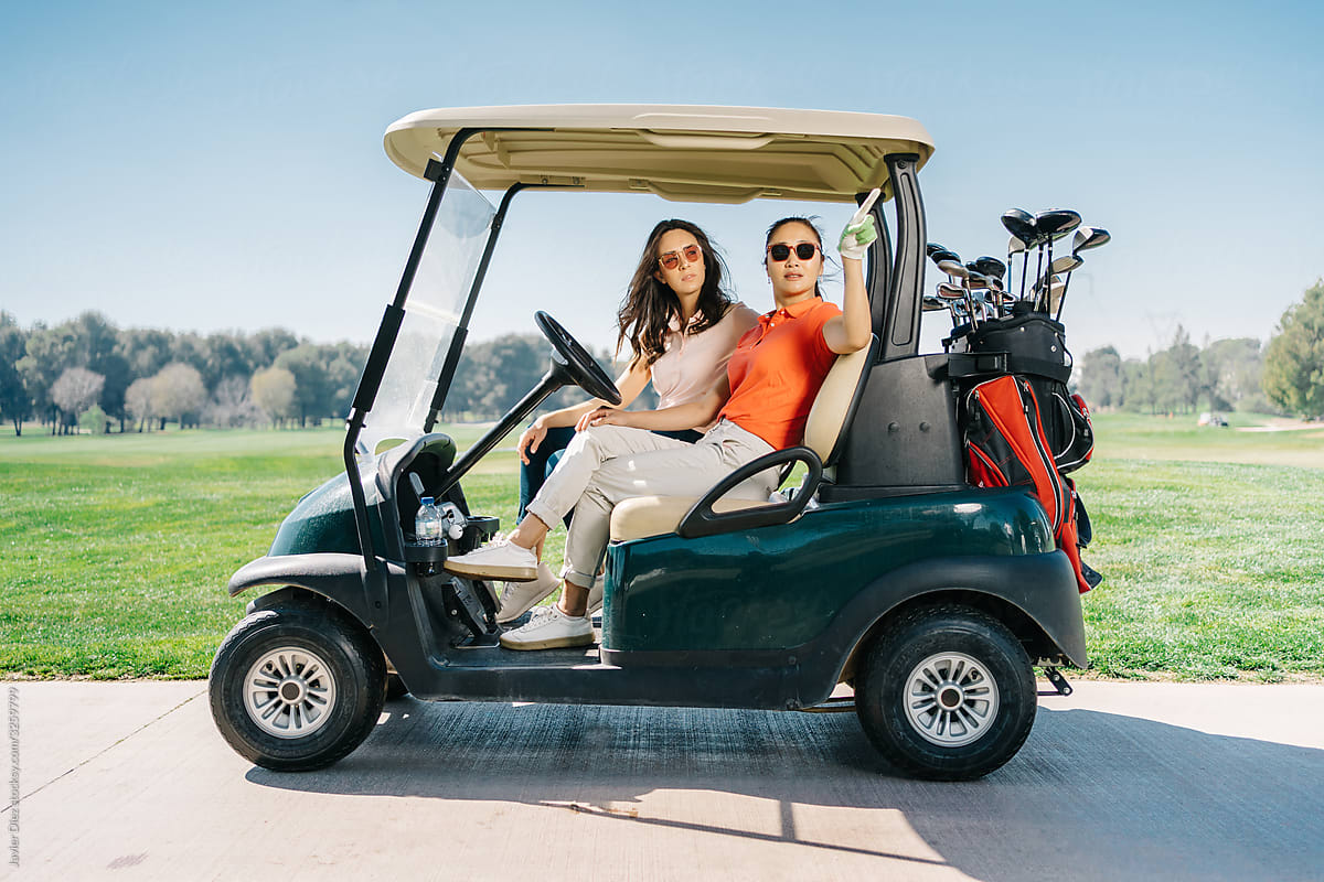 Young women in golf buggy on path