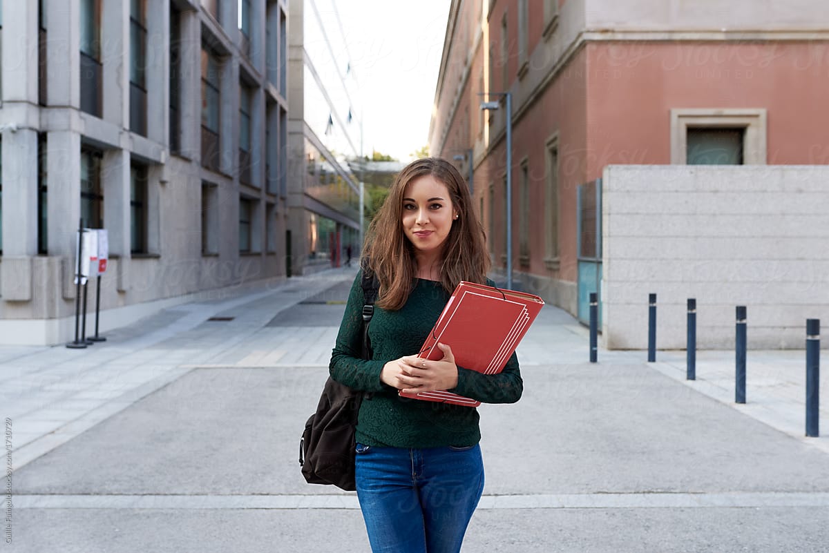 Pretty student with studies posing at street