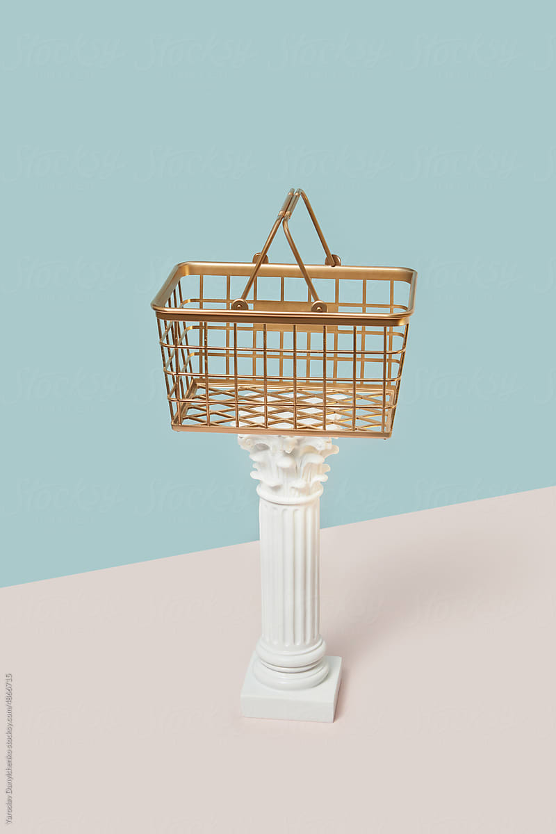 Gilded shopping basket on classic pillar.
