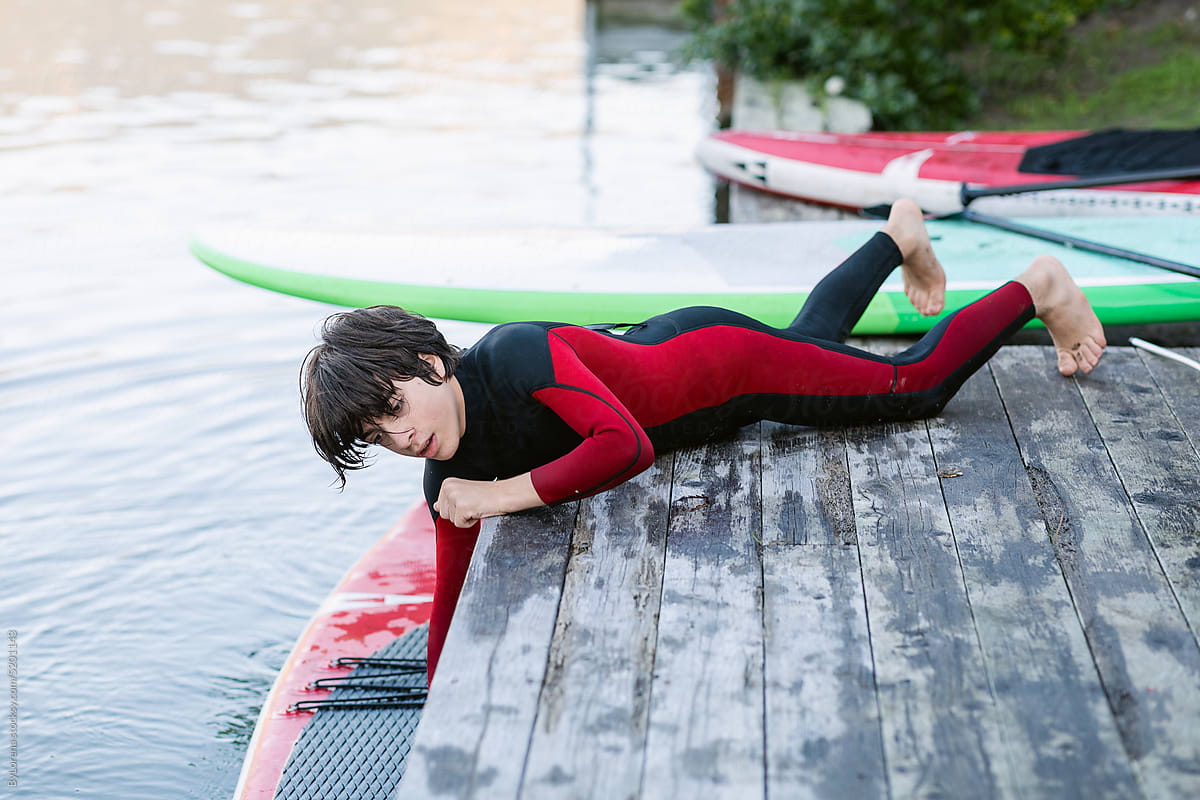 Teenage surfer enjoying in wetsuit in a lake