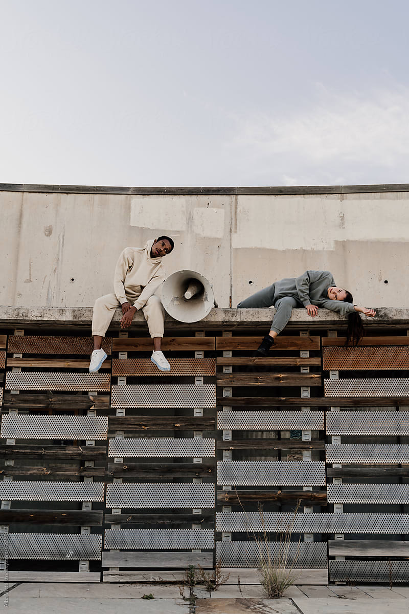 Friends laying down on top of wall next to megaphone