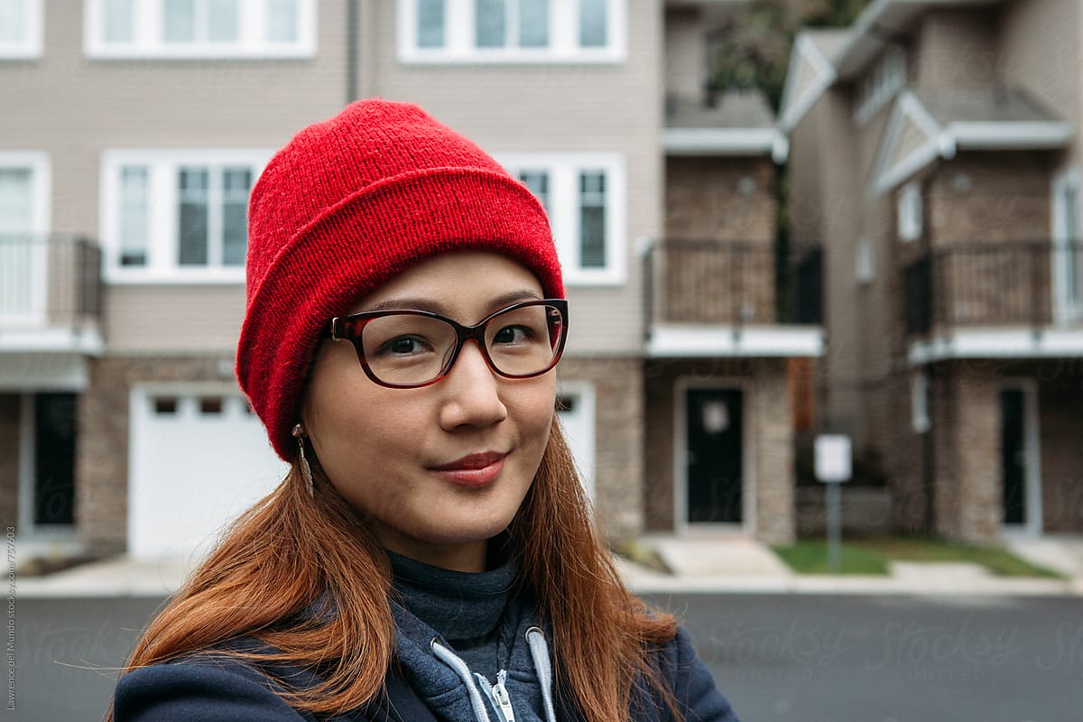 Portrait of a beautiful woman wearing cold weather clothes with new houses in the background