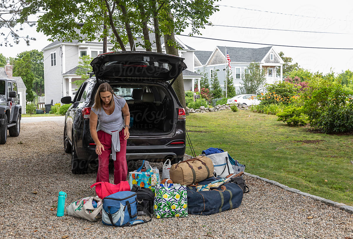 Girl Packing luggage in car for family road trip