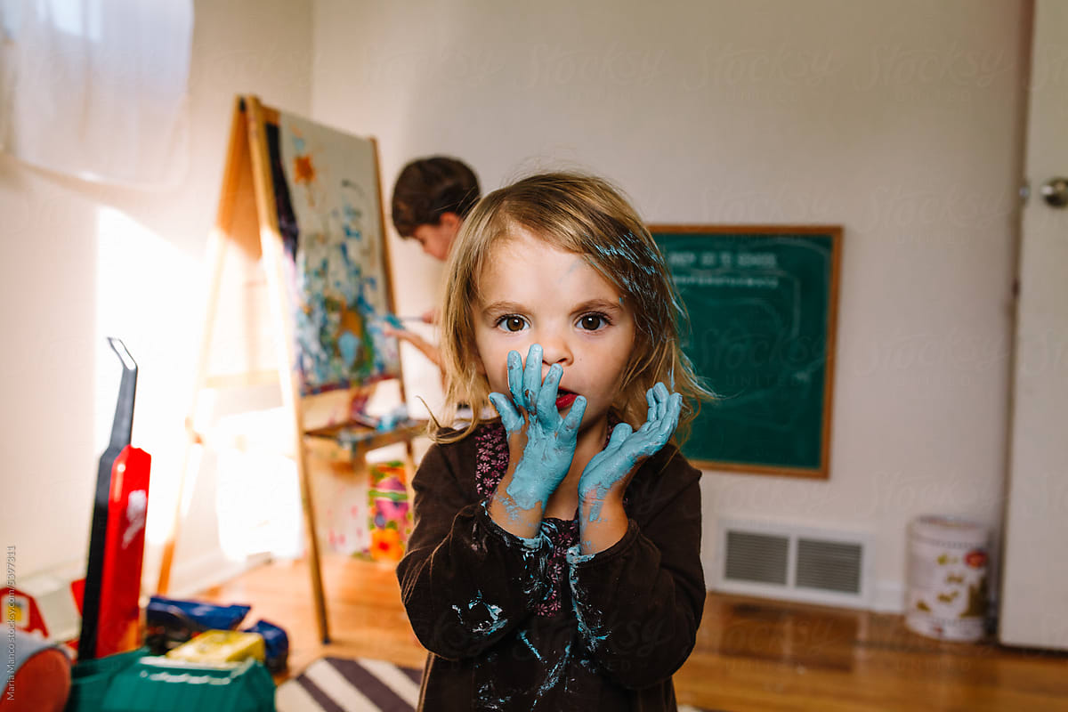 girls makes a huge mess with blue paint