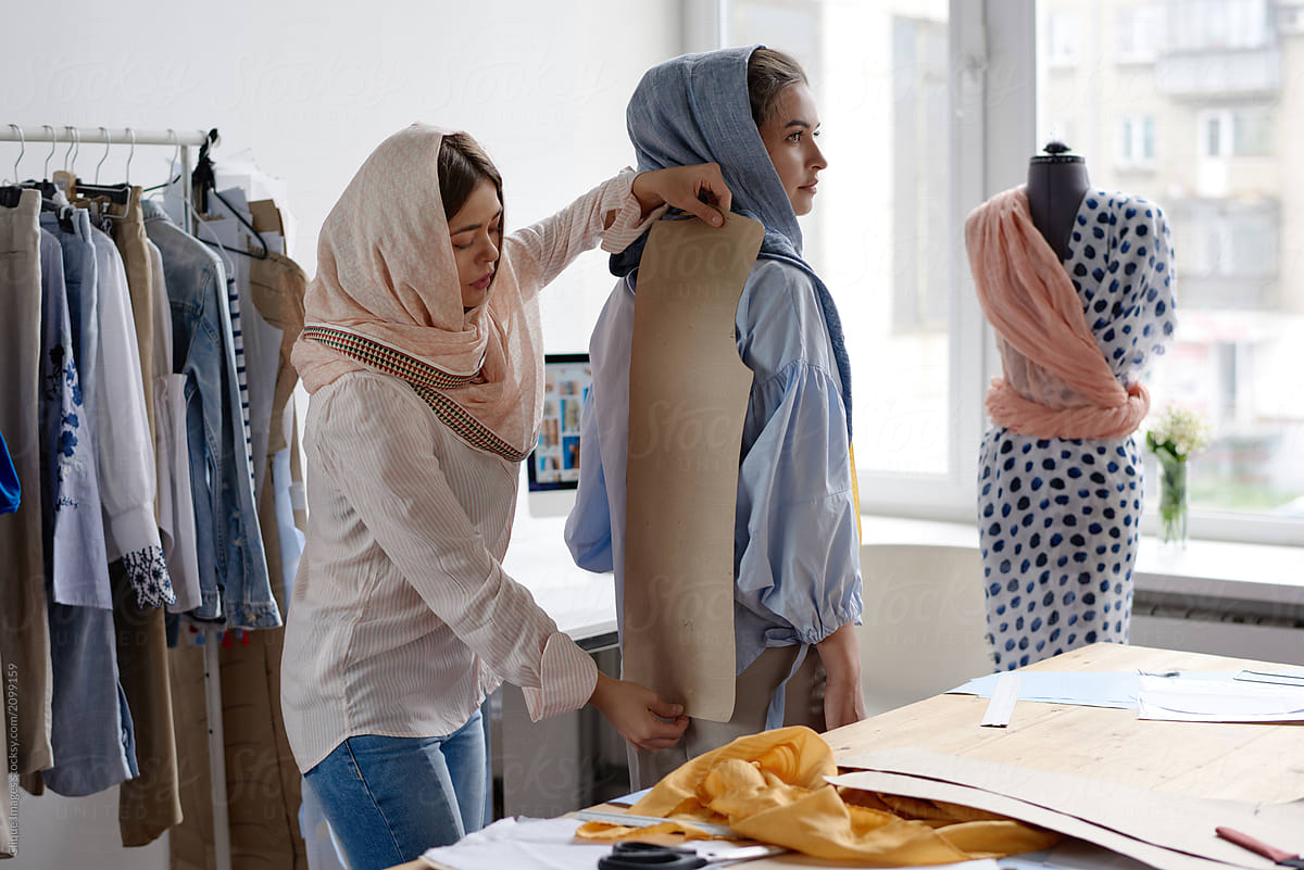 Women applying paper template of dress