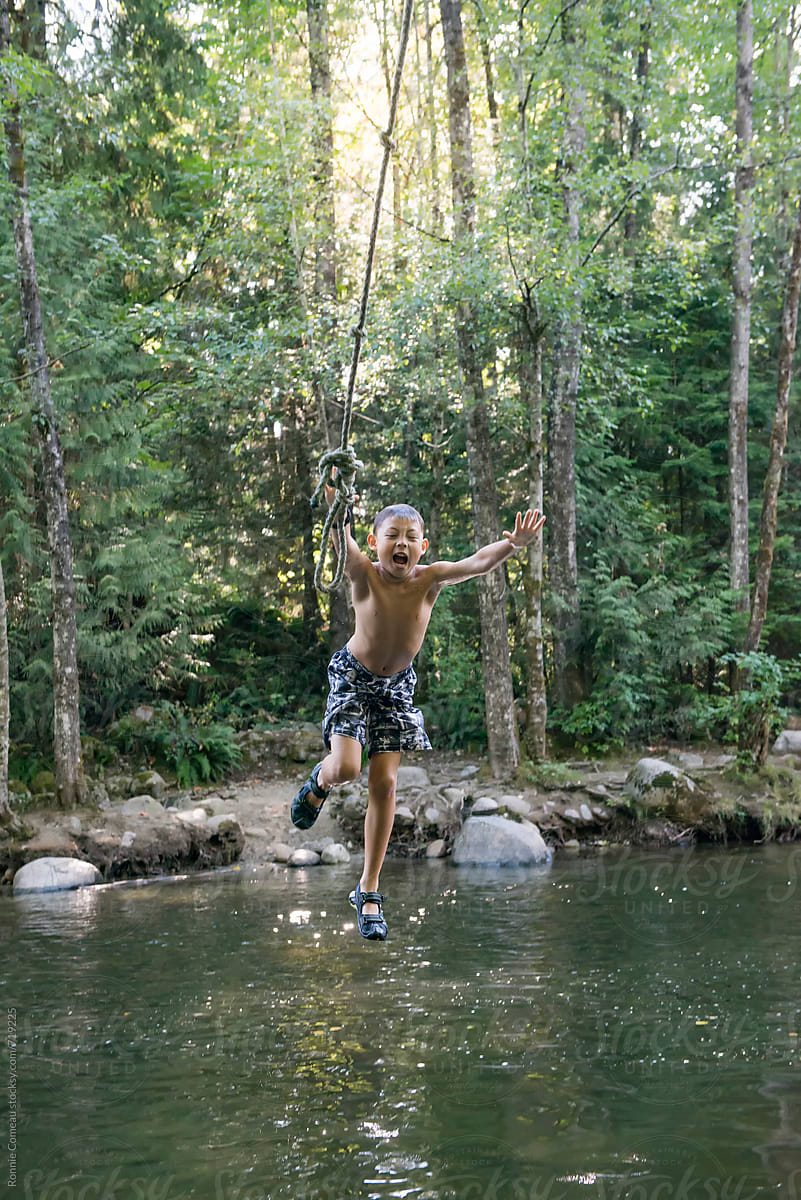Boy Letting Go Of Rope Swing In River