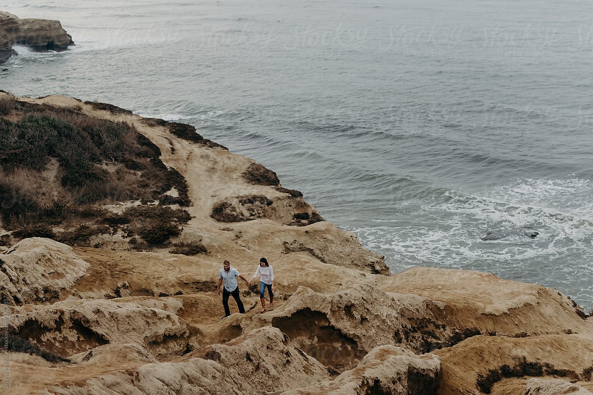 A Young Couple Walking Along Ocean Cliffs