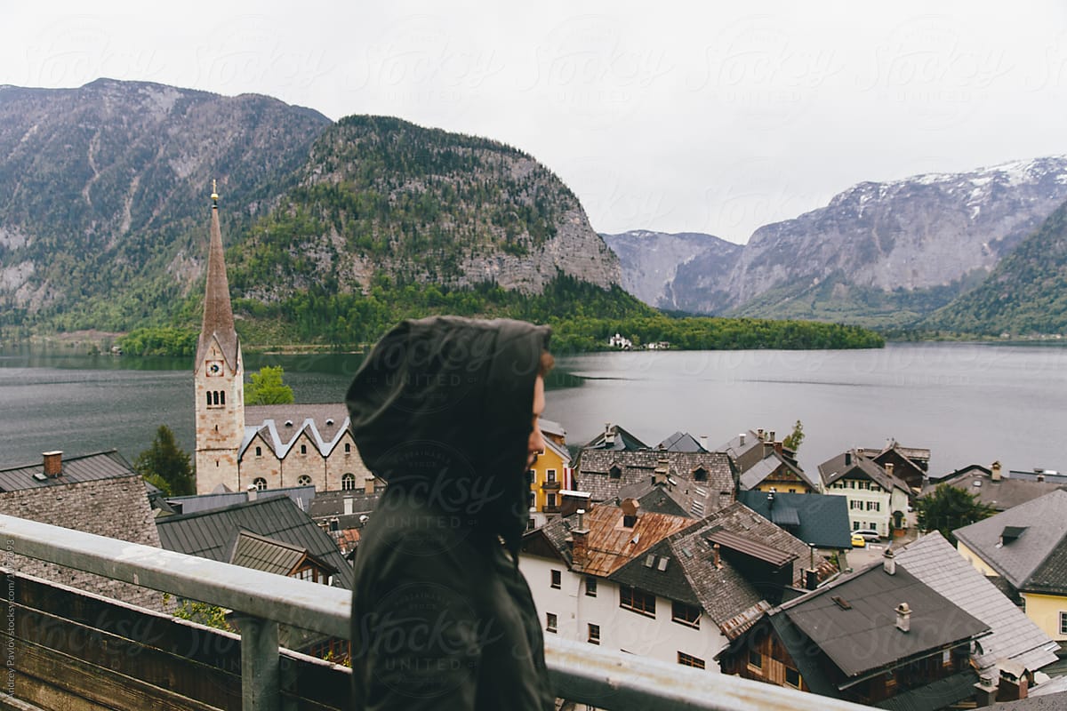 Unrecognizable tourist against of Austrian village in mountains
