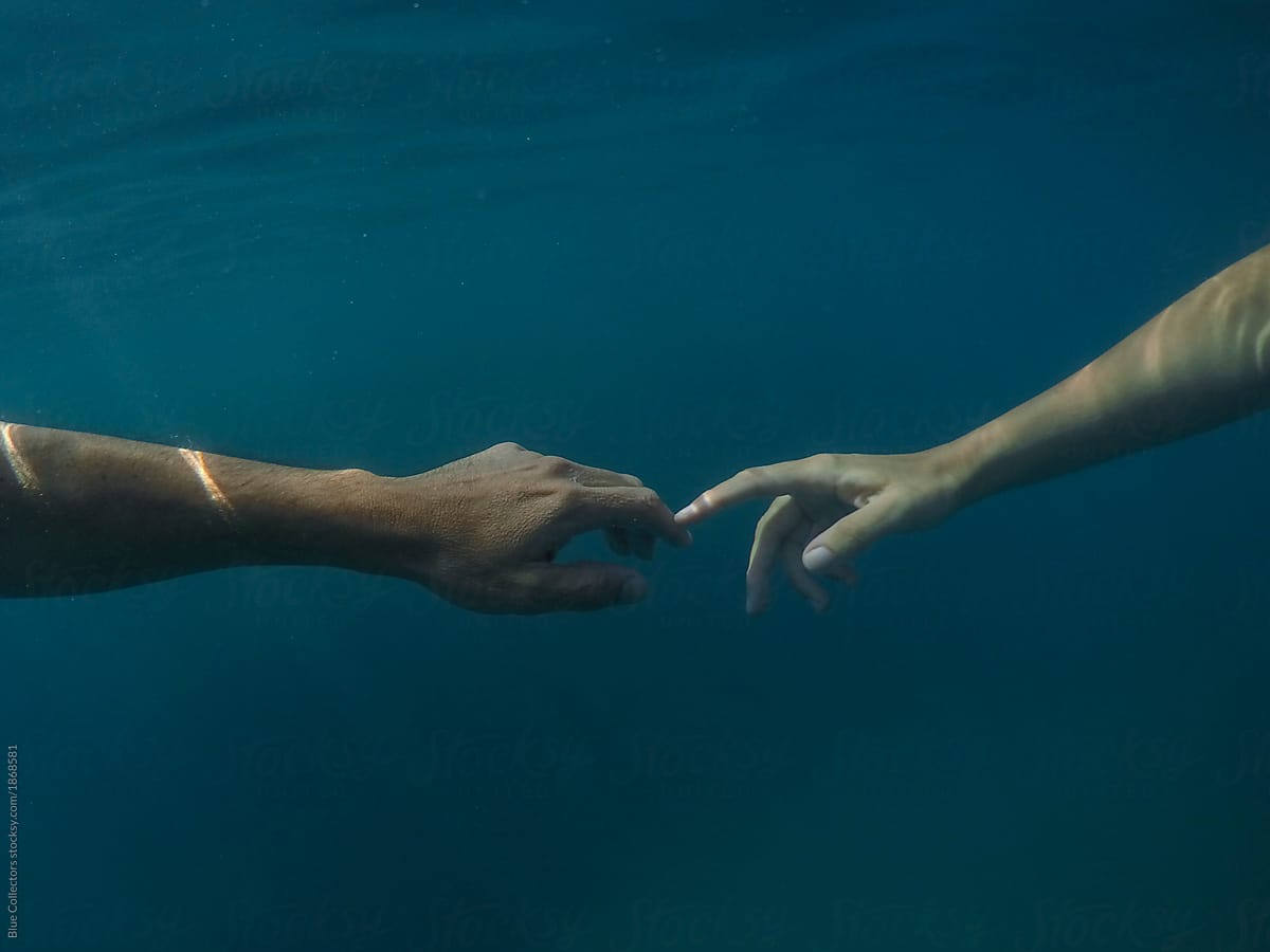 Peaceful couple floating in the water from underwater view