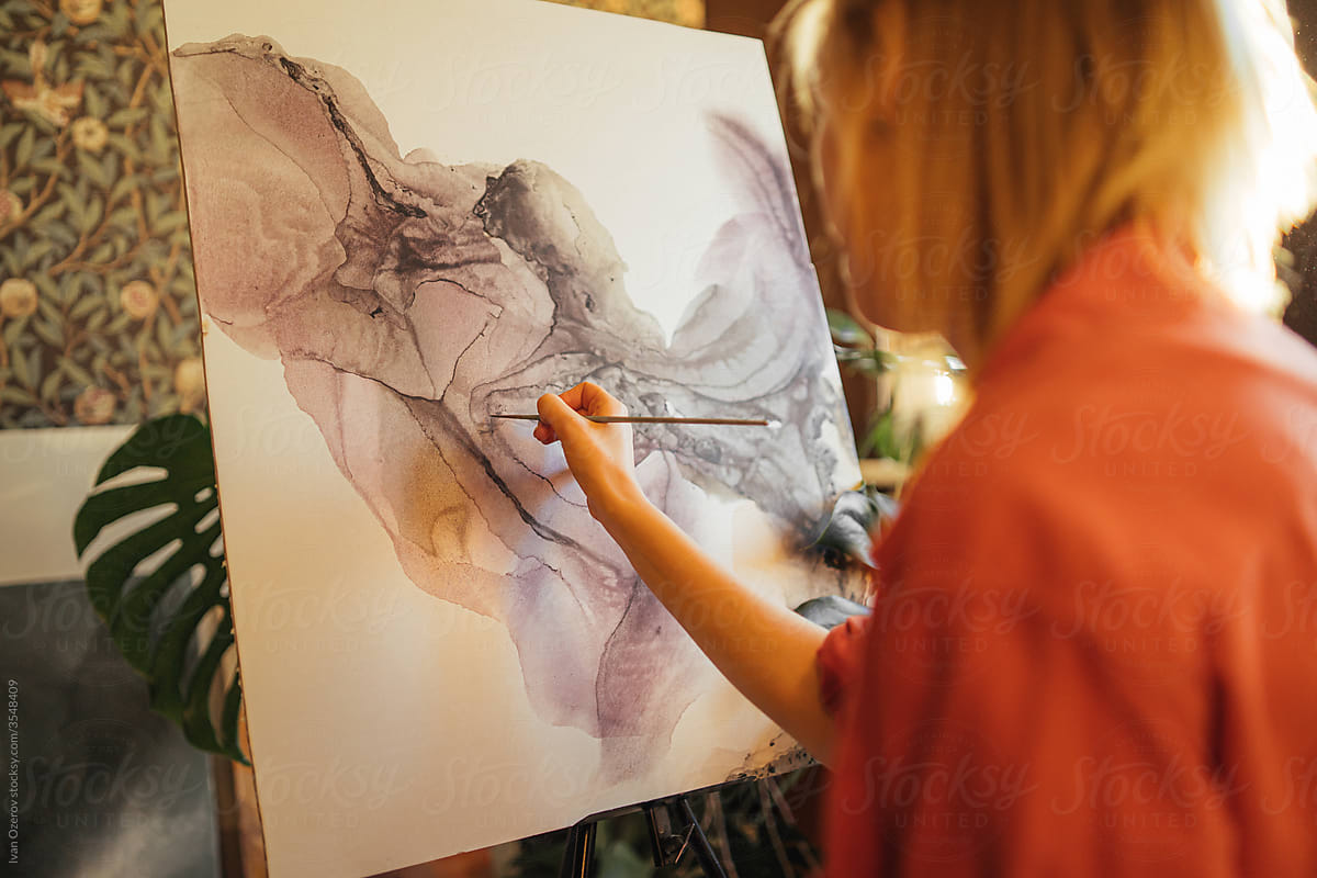 woman artist paints an abstract picture